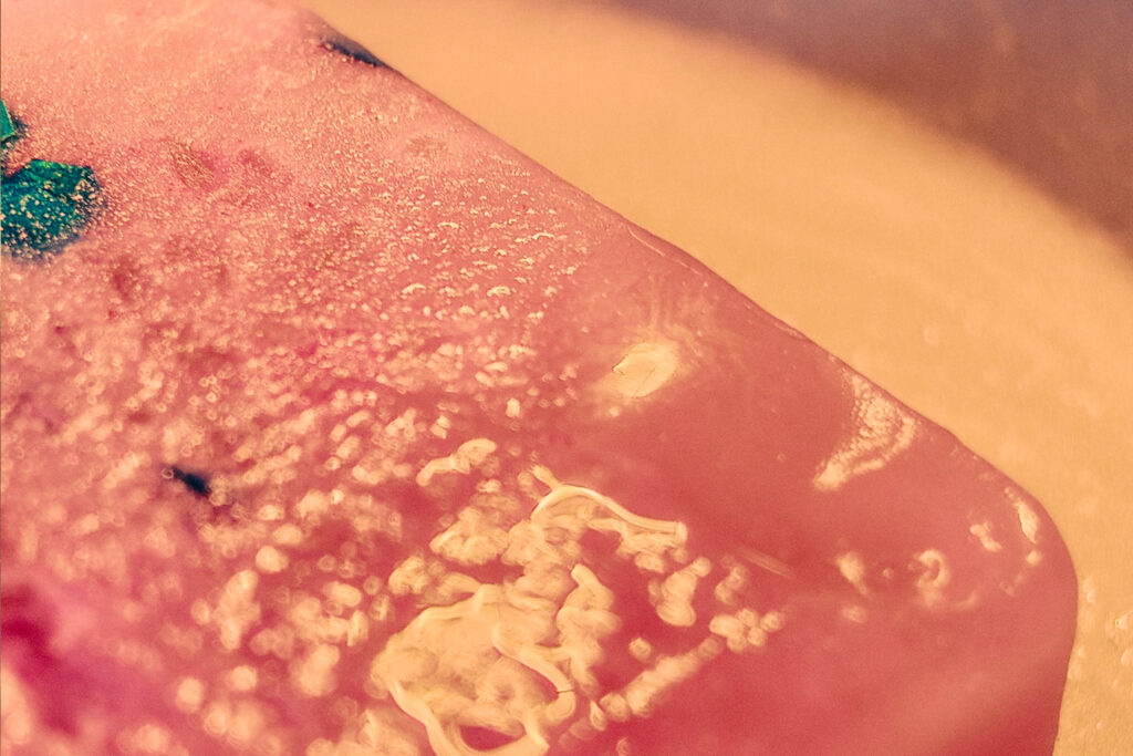 Close up of melted wax melt in a burner dish releasing fragrance