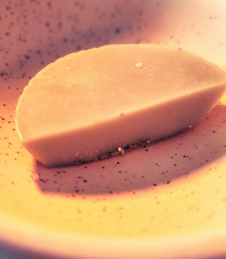 Large piece of wax melt placed in a wax burner dish before melting