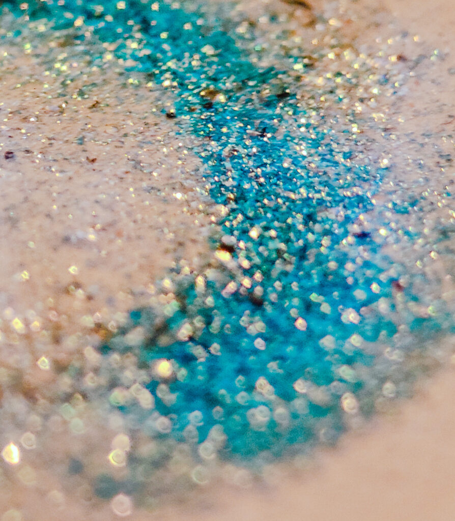 Melted snap bar wax melt piece in a burner dish with shimmering glitter mica close up