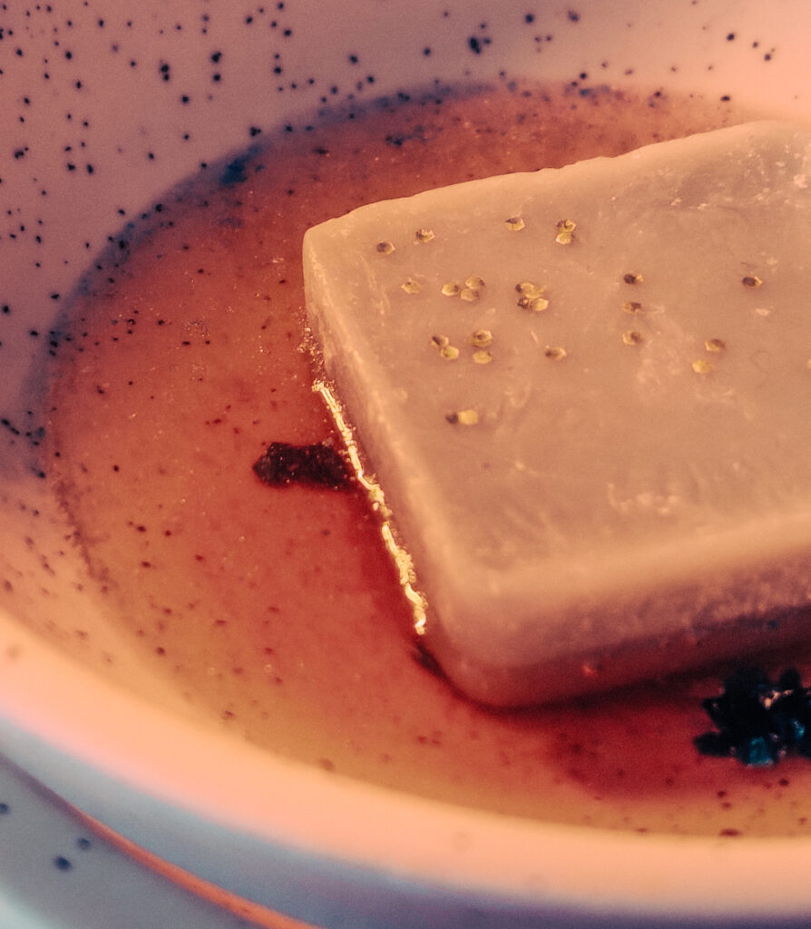 Wax melt cube melting in a burner dish releasing fragrance