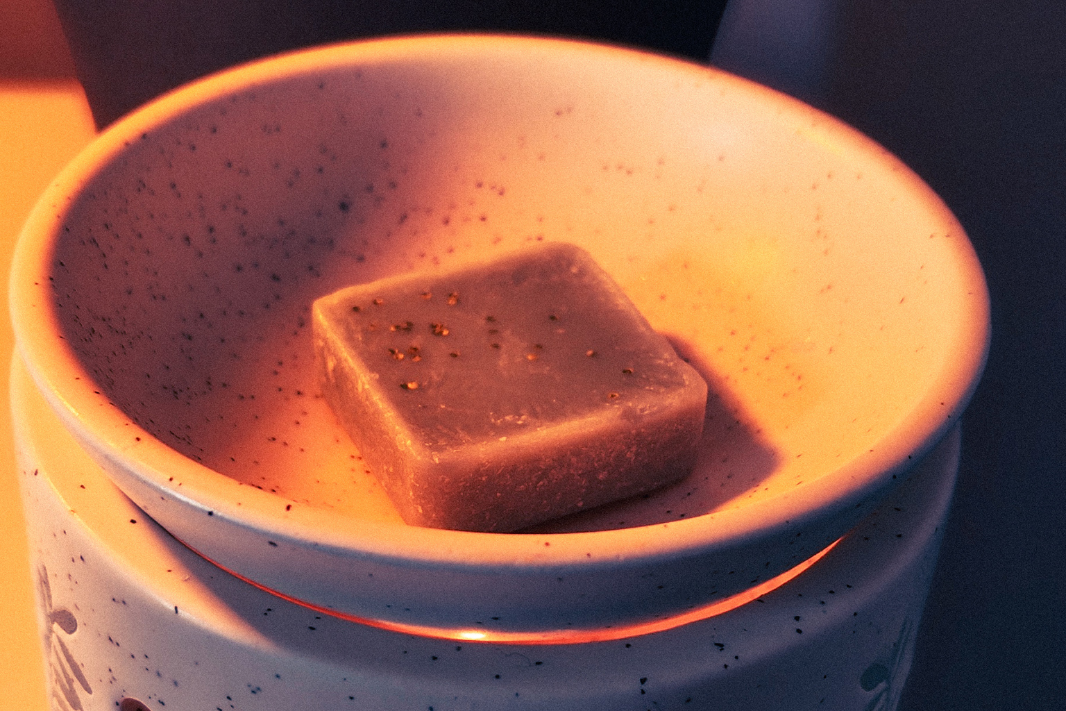 Single wax melt piece placed in a wax burner dish before melting